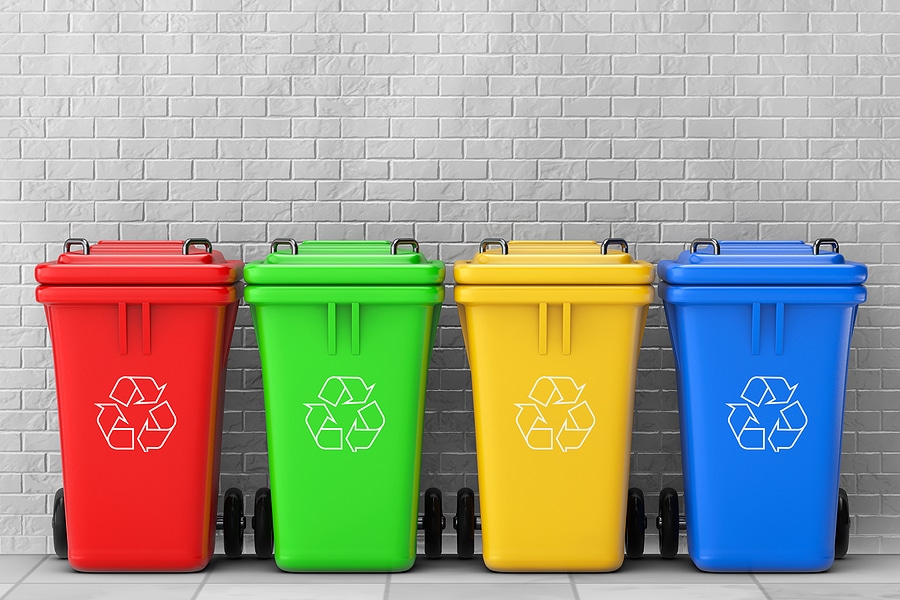 Multicoloured Garbage Trash Bins in front of brick wall. 3d Rendering